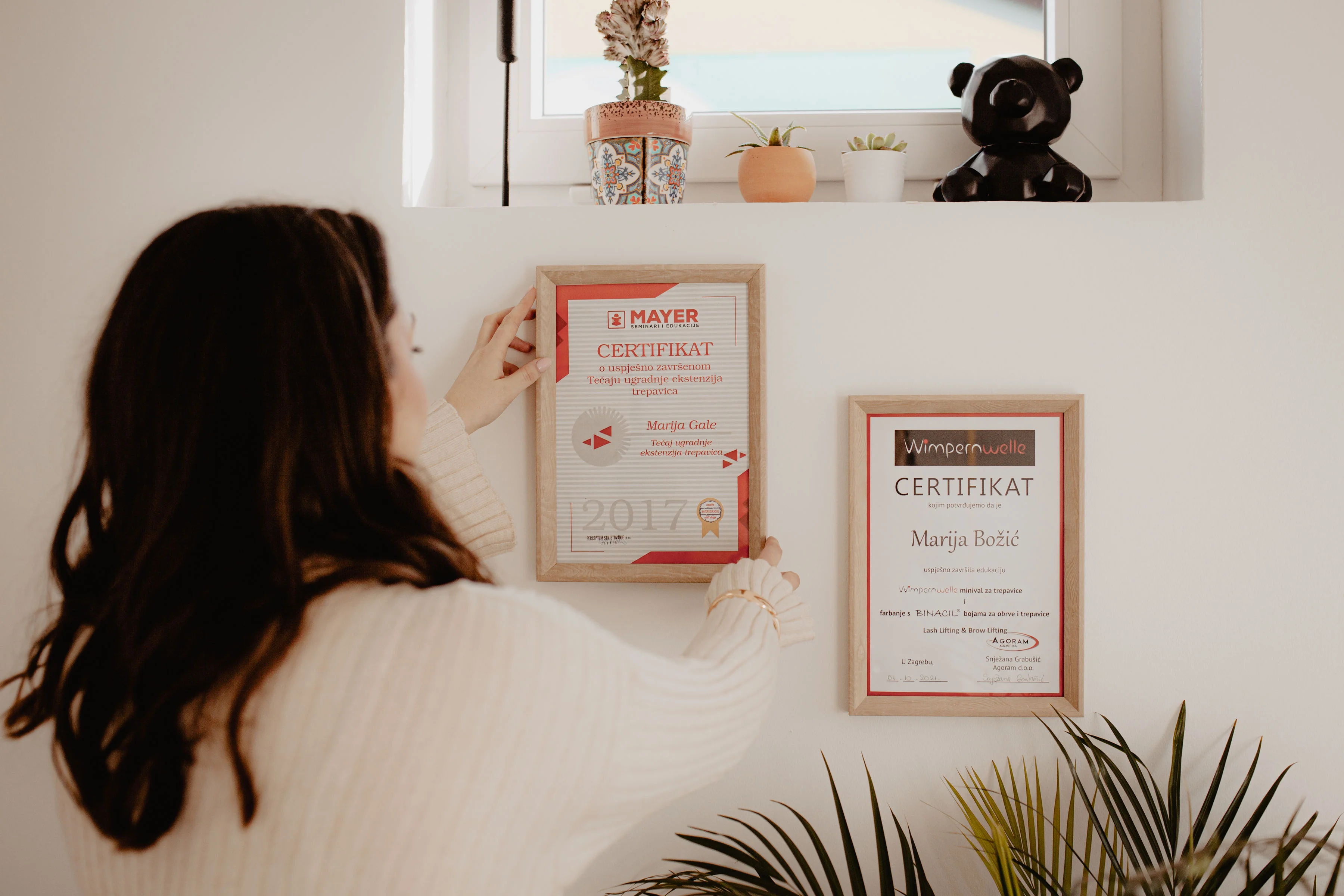Marija vješa certifikate u studiju